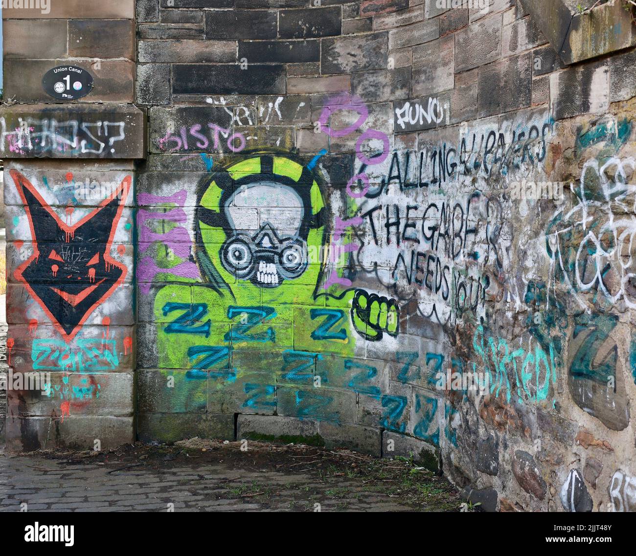 Colorful graffiti on a stone wall along the canal path in Edinburgh Stock Photo