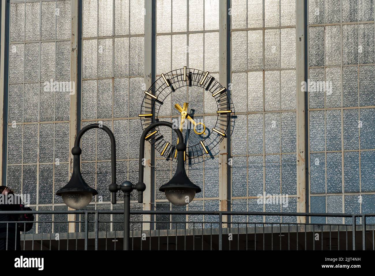 A beautiful architectural clock on a glass wall at daytime Stock Photo