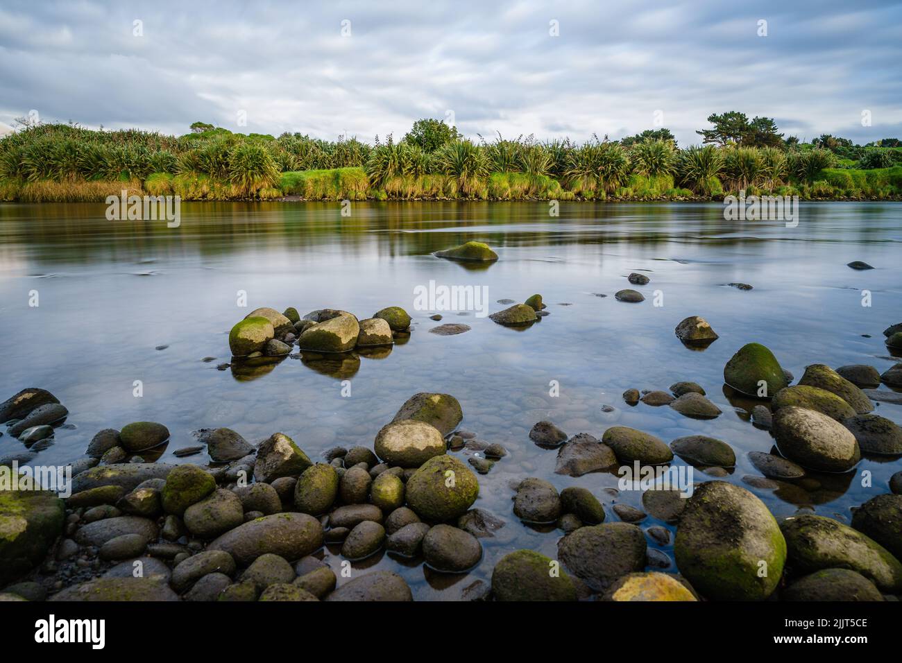 A natural view of the river filled with big rocks in New Plymouth, New Zealand Stock Photo