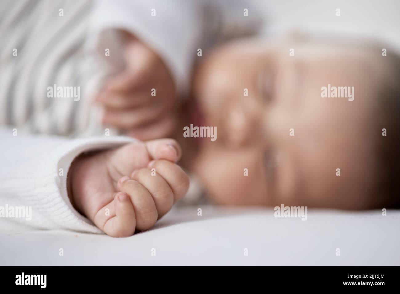 Babies need lots of sleep to grow. Closeup shot of a babys hand while asleep at home. Stock Photo