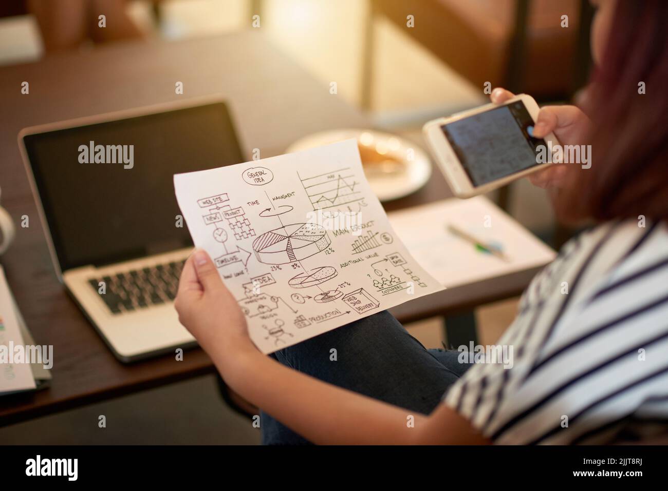 Document with charts and drawings of general idea in hands on young