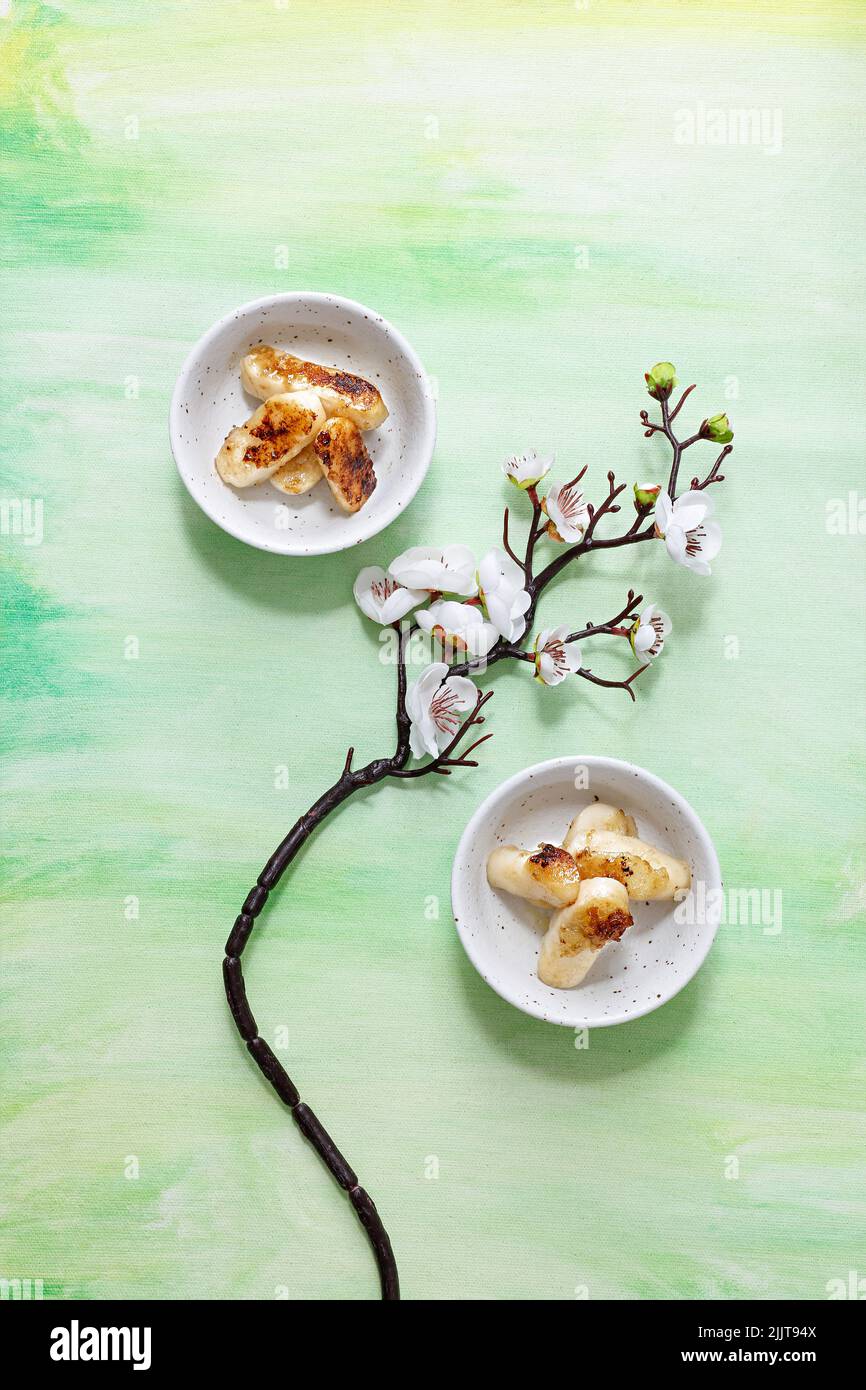 The bowls of rice cake decorated with the cherry tree branch with flowers Stock Photo