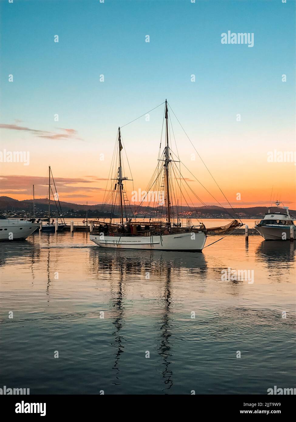 A vertical shot of boats parked in a pier in the sunset Stock Photo - Alamy