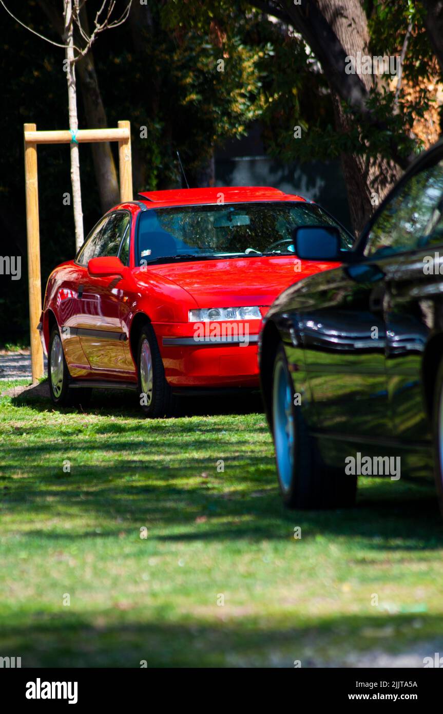 A vertical shot of old red Opel Calibra on display at a car show Stock Photo