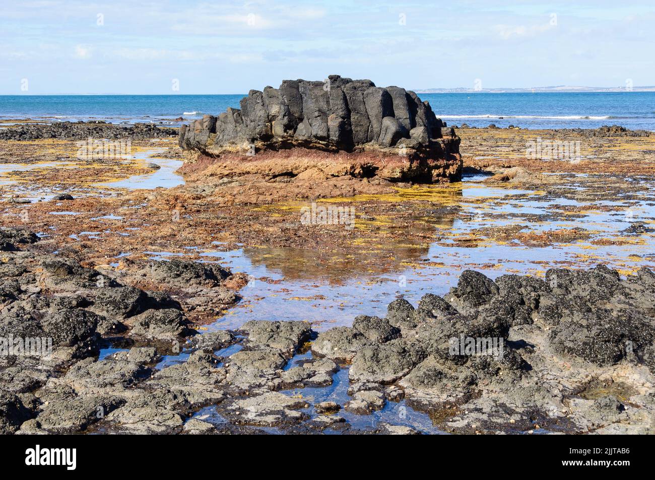 Volcanic black rocks on Dodds Creak Beach - Flinders, Victoria, Australia Stock Photo