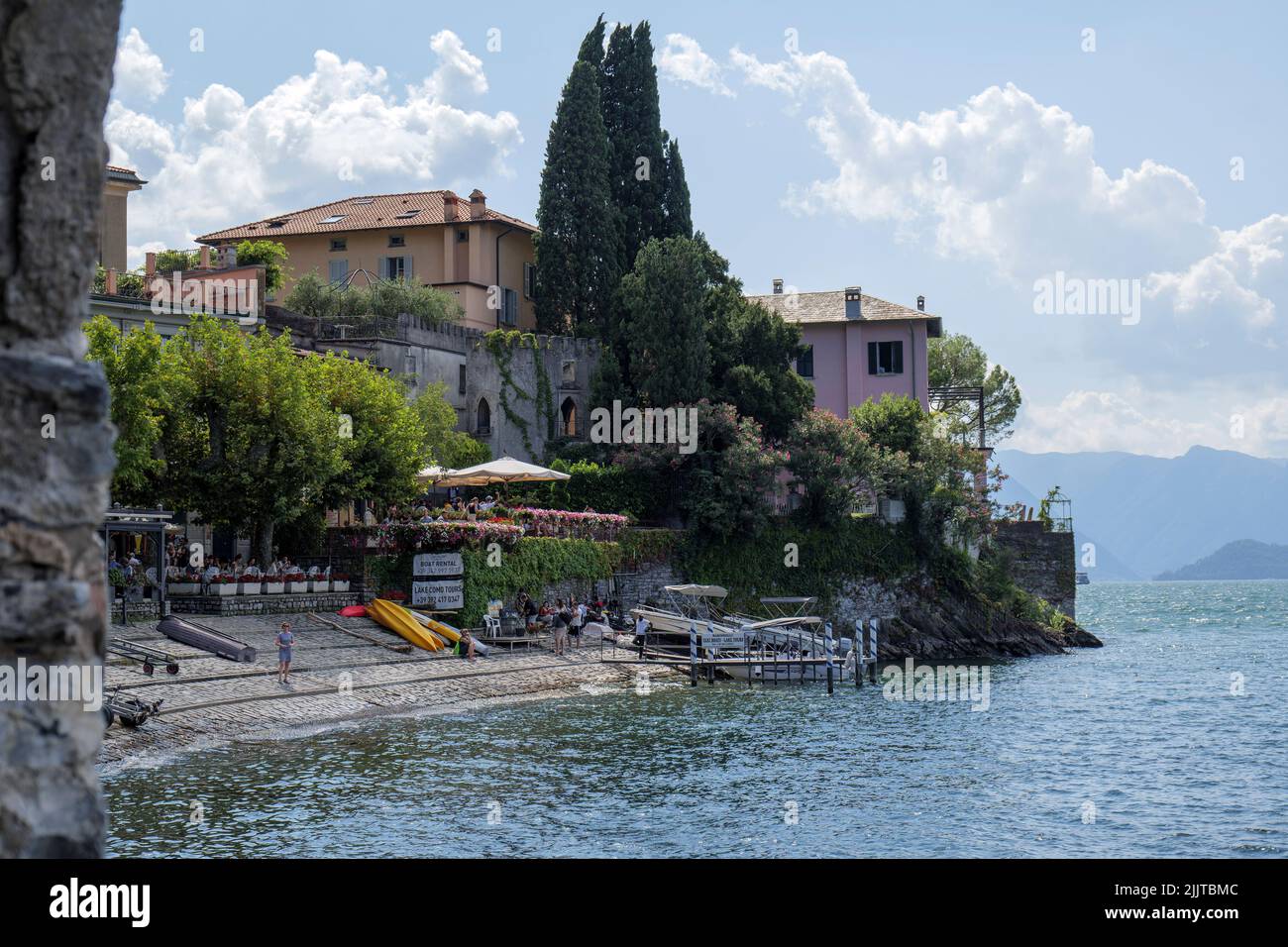 The scenic harbor of Varenna City at Lake Como in Italy under a blue sky Stock Photo