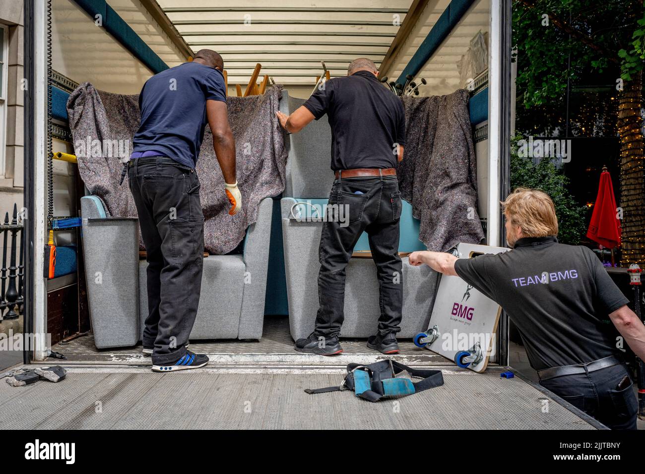 Corporate office furniture including coat stands and seating are being loaded into a van and taken away for temporary storage in the Midlands, by removal men in the City of London, the capital's financial district, on 27th July 2022, in London, England. Stock Photo