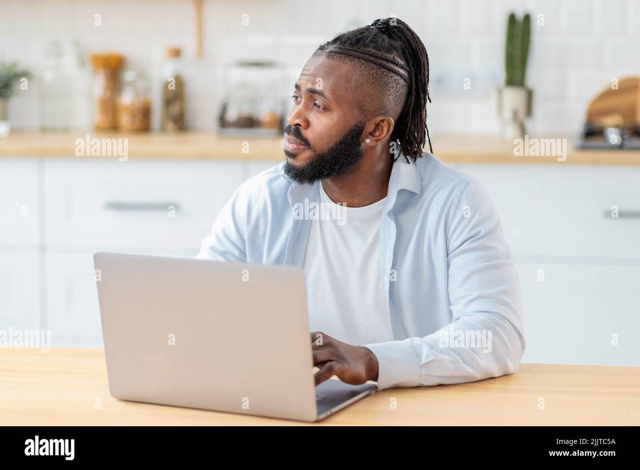 Portrait of focused freelancer working remotely online using laptop computer Stock Photo