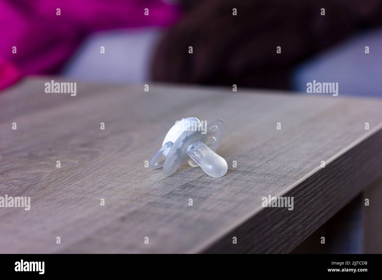 A closeup of a baby pacifier or soother on a wooden table Stock Photo