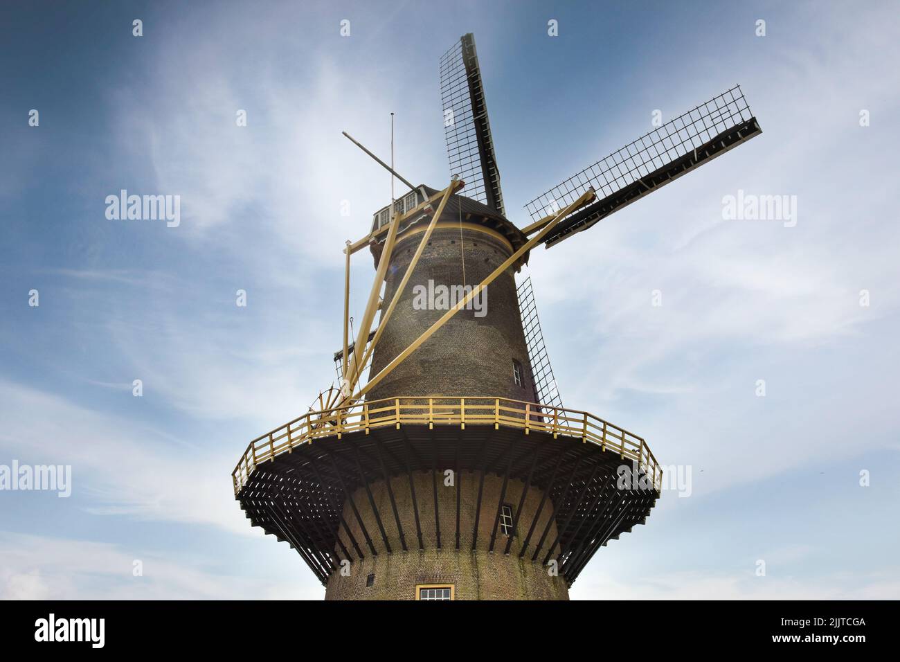 A low angle of a medieval windmill with sails on the sky background Stock Photo