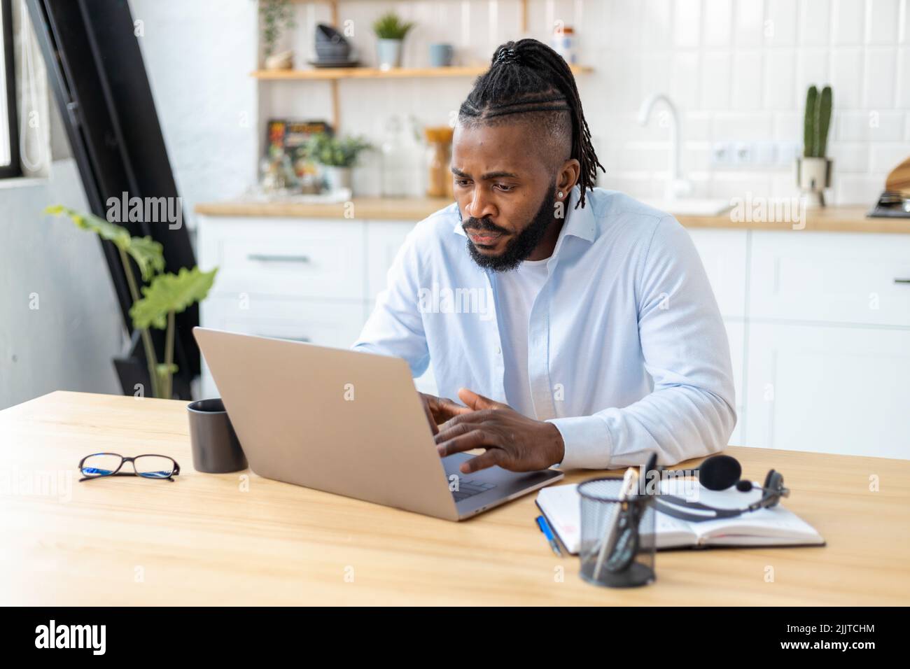 concentrated African American freelancer using laptop computer working