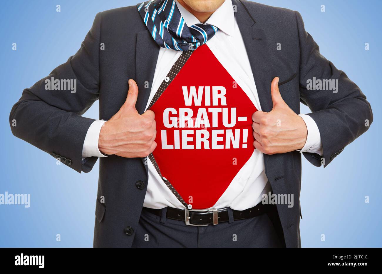 Businessman in a suit shows lettering Wir gratulieren! (German for: Congratulations from us!) under shirt Stock Photo