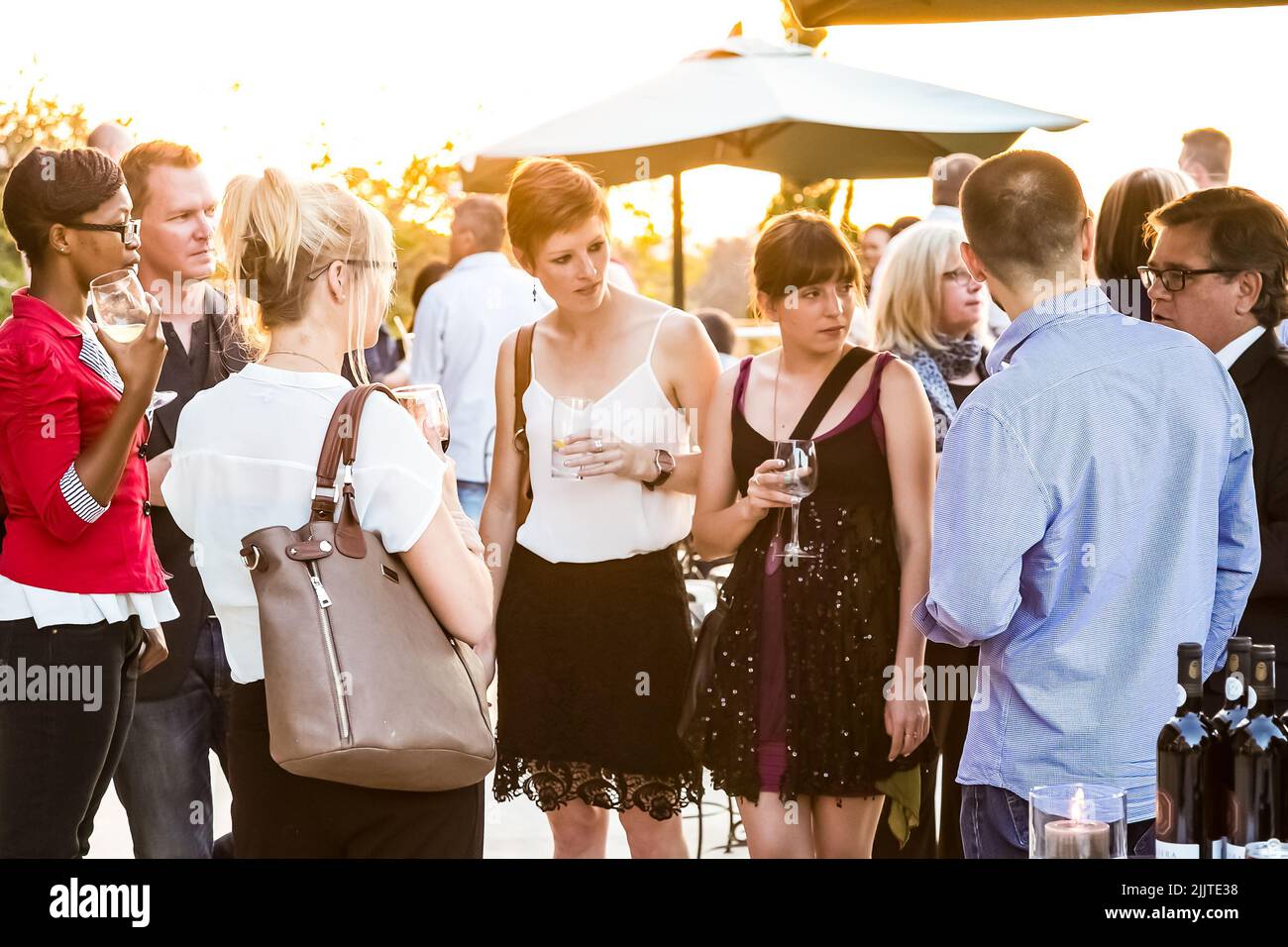 Diverse people socializing at an outdoor cocktail party in Johannesburg Stock Photo