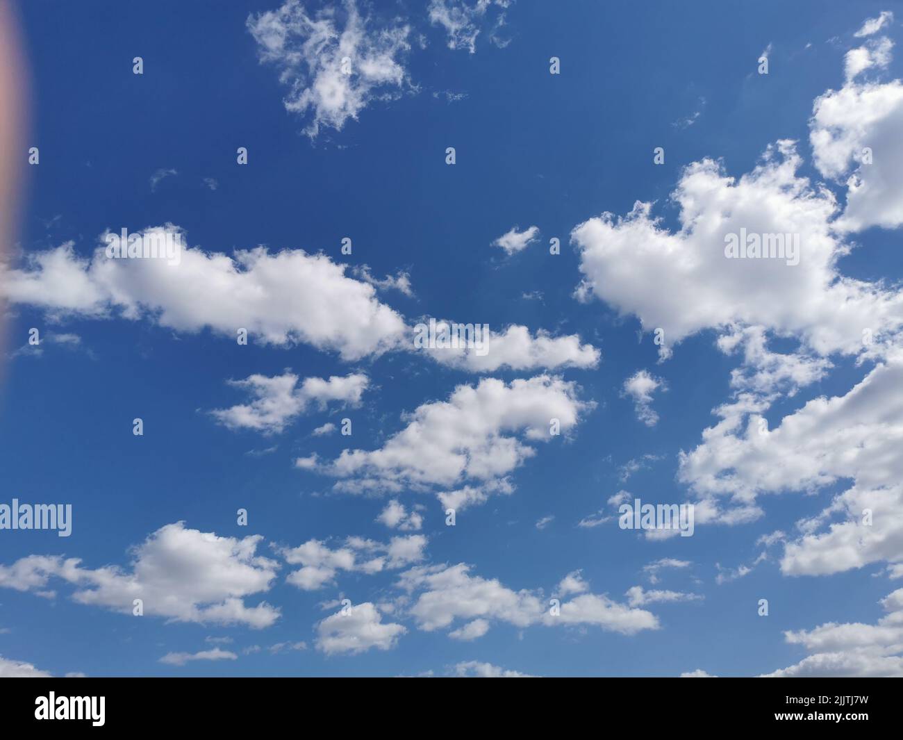 Scenic cloudscape with white clouds soaring in the blue sky Stock Photo