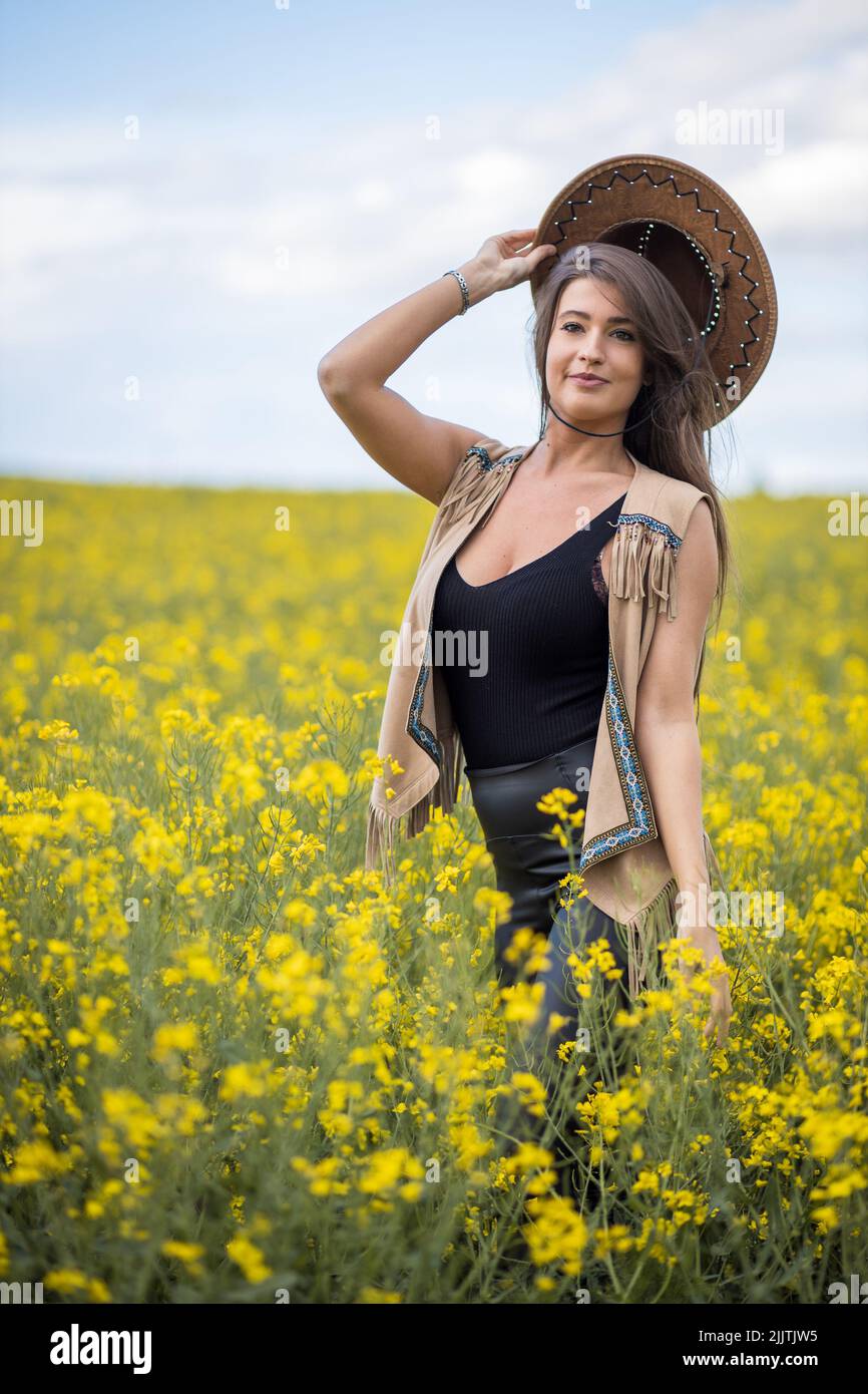 A closeup of an attractive girl posing in a field in a daylight Stock Photo