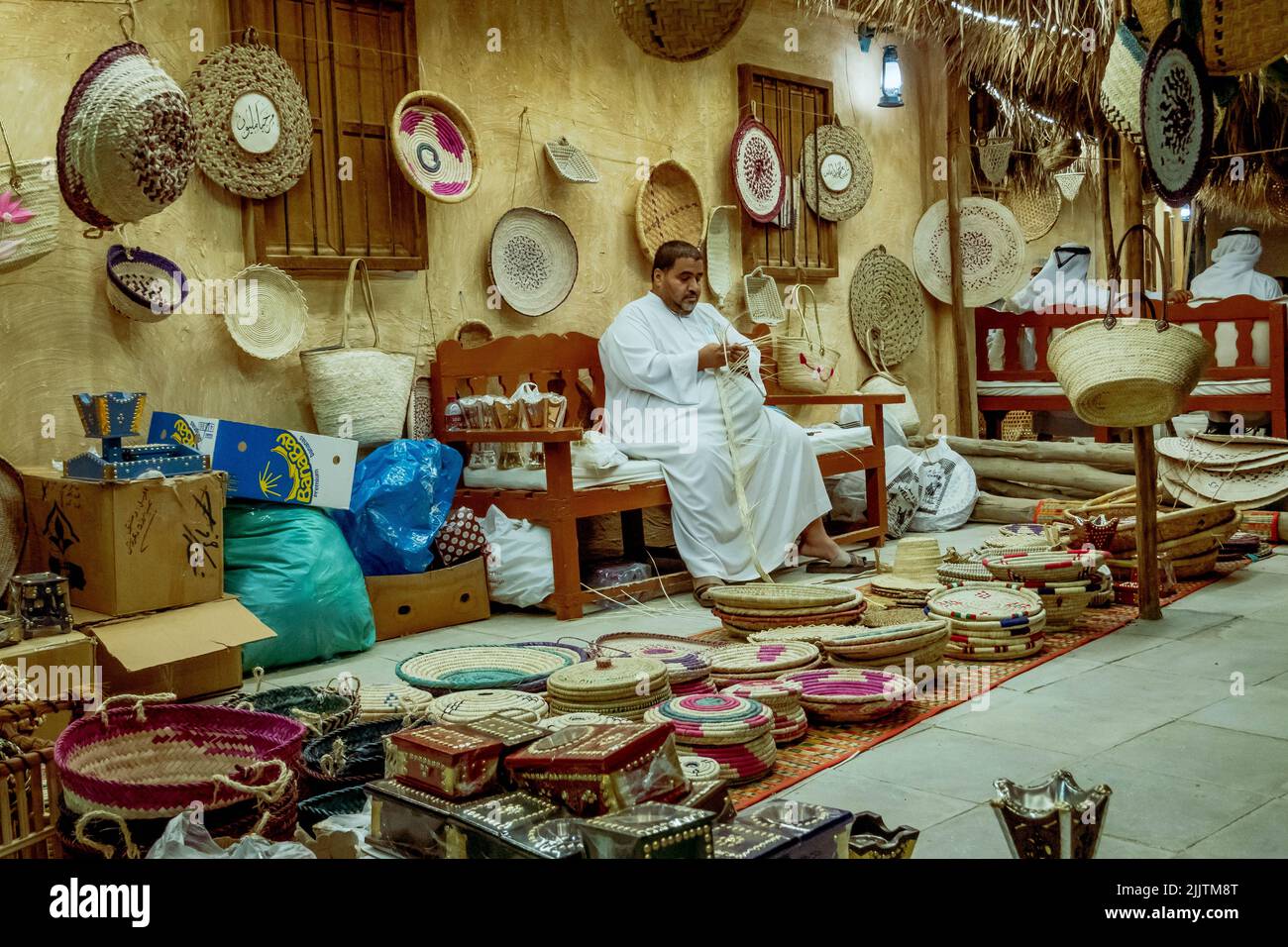 A male Omani vendor selling handicraft baskets during Katara Traditional Dhow Festival in Doha, Qatar Stock Photo