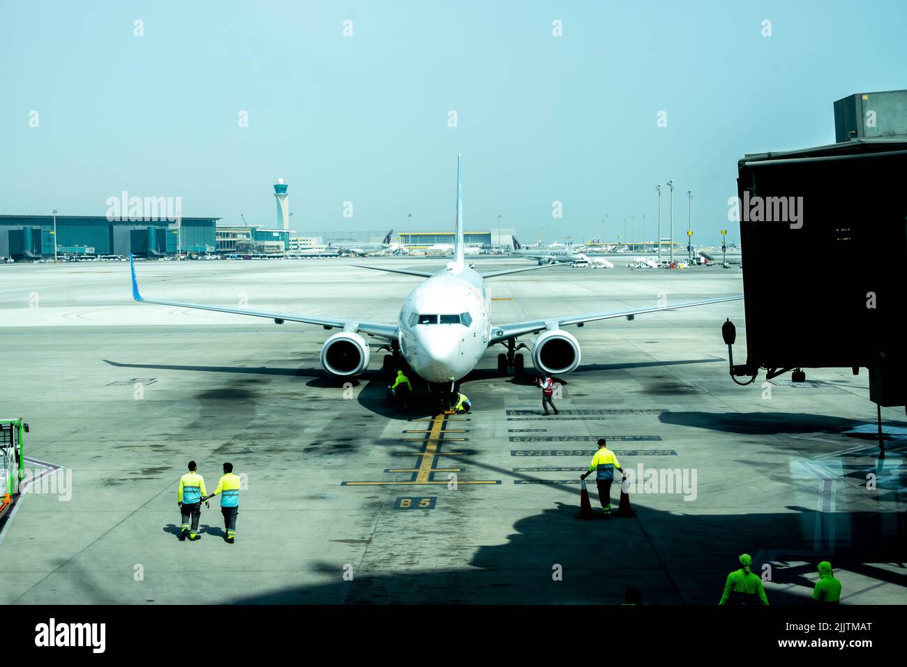 Male workers standing by a Fly Dubai plane at Hamad International Airport Stock Photo
