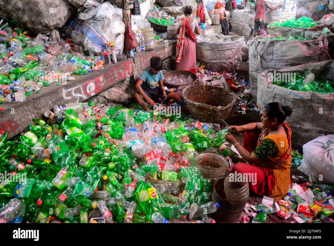 Laborers sort through polyethylene terephthalate (PET) bottles in a