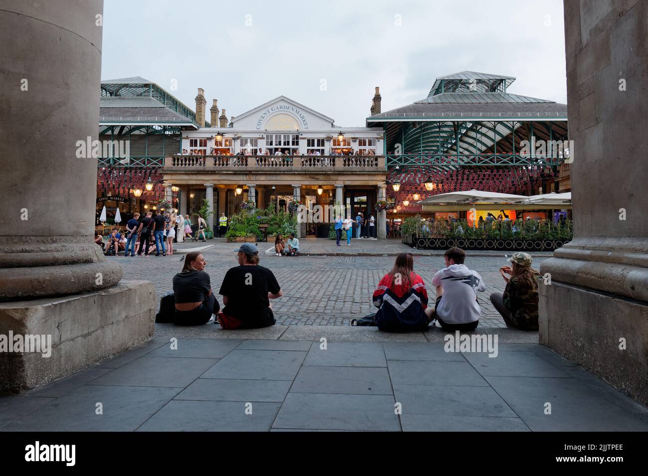 London, Greater London, England, July 20 2022: People sit and relax in the main square of Convent garden, famous for its street acts and market and ch Stock Photo