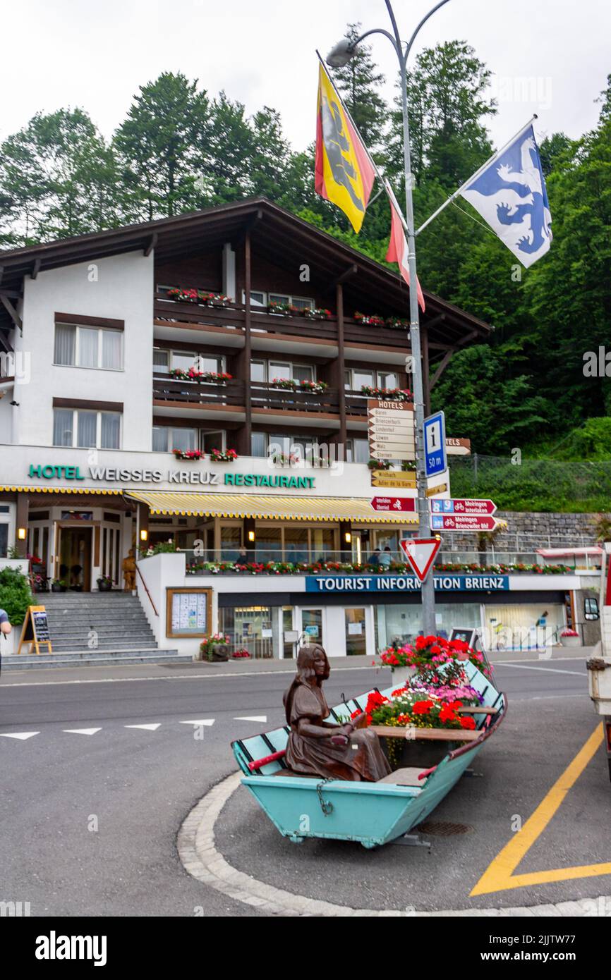 A vertical shot of a decorative boat with flowers and a typical cottage