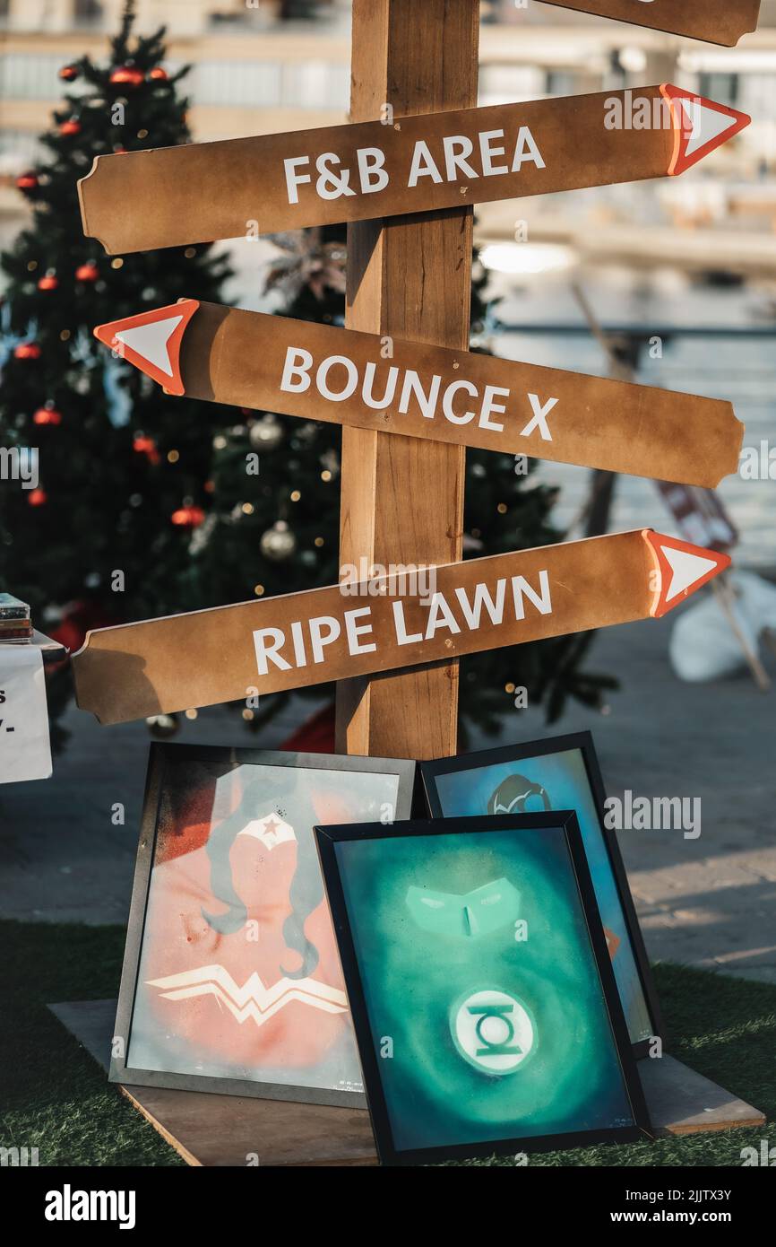 A vertical shot of wooden direction signs with pictures in Dubai Stock Photo