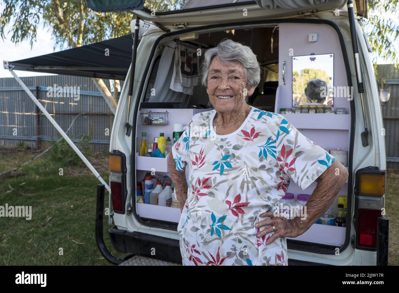 84 year old, traveler, pensioner, Thelma Evans with her Toyota Hi-Ace van in the tourist park in Winton, Queensland.   In 1988 while traveling around Ausralia in a caravan with her husband, Thelma became a widow. After a period of mourning she decided to keep traveling. She replaced the caravan with a more easily handled van and since that time she has driven over 400,000 km crisscrossing the country. She has travelled the Gibb River Road, five times and has an encyclopeadic knowledge of the roads, rivers, mountains, billabongs and campsites of Australia.  Her campervan, fitted out by her carp Stock Photo