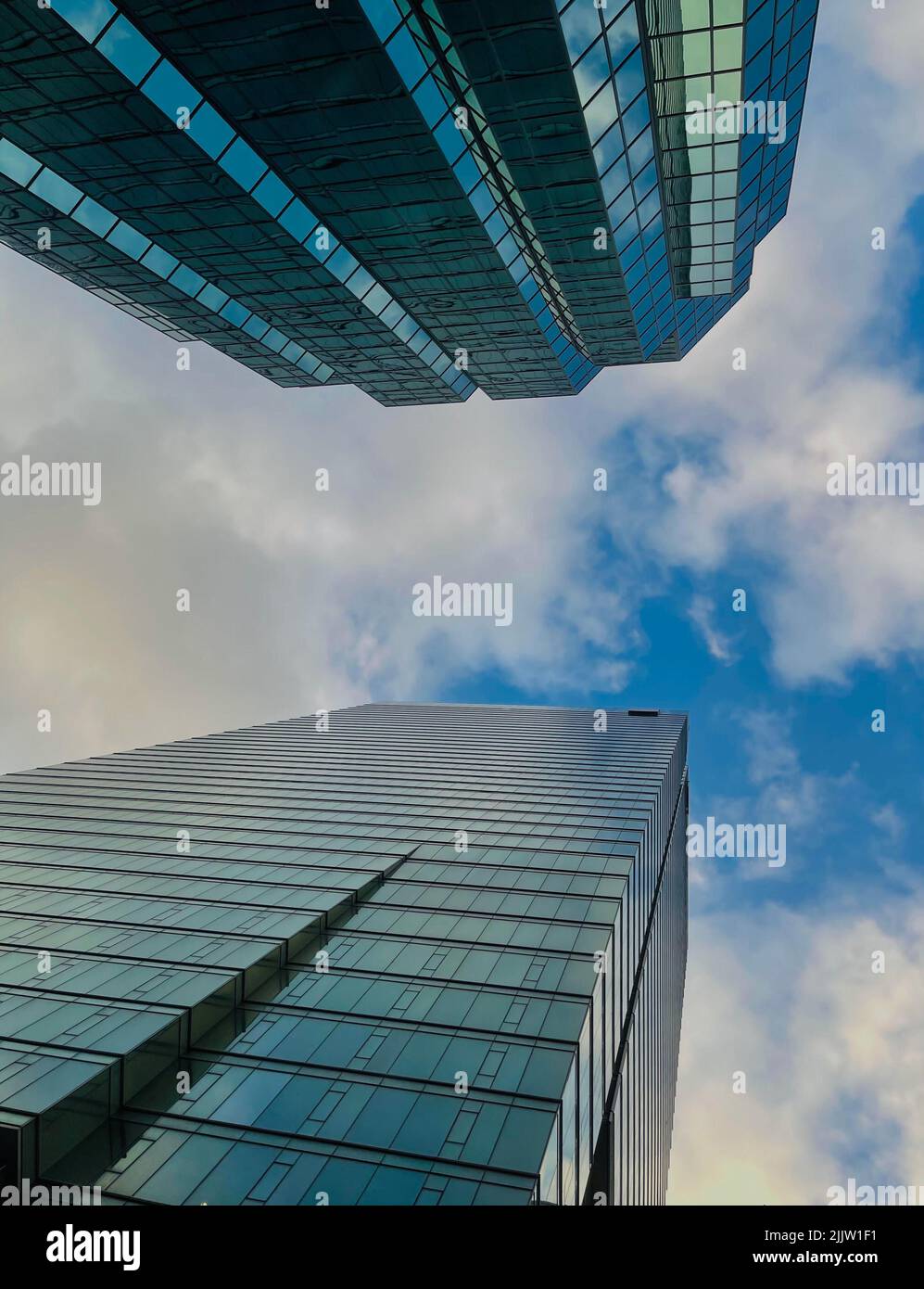 A vertical low angle shot of beautiful skyscrapers against a blue sky ...