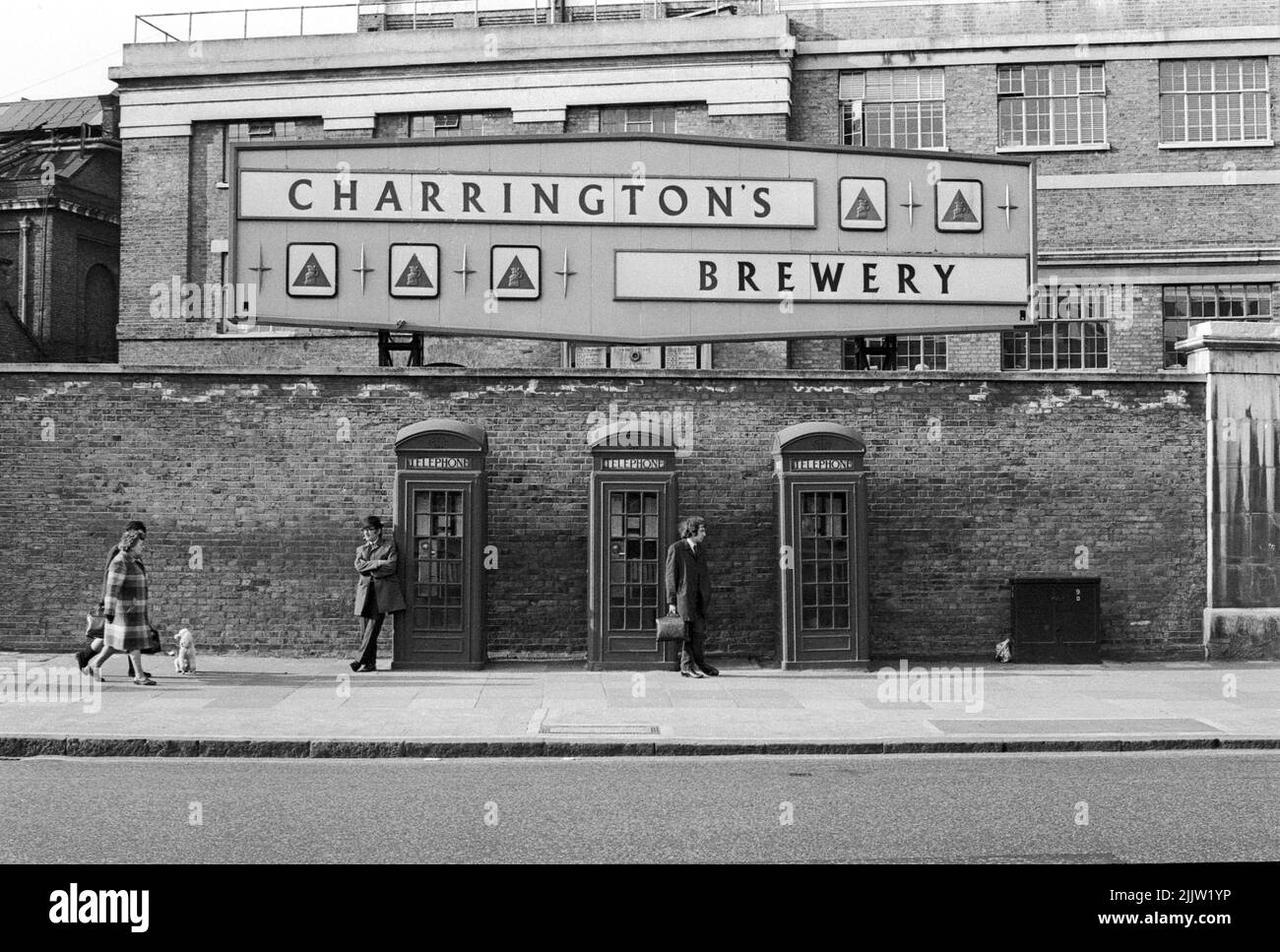 Three old style telephone boxes photographed in 1967 against a backdrop of the old Charrington's Brewery in Kings Road at Worlds End, Chelsea, London, UK Stock Photo