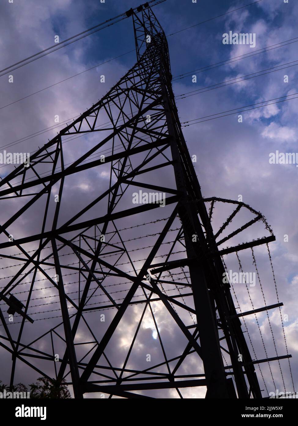 I love electricity pylons; I find their abstract, gaunt shapes endlessly fascinating. Here we are looking up at a giant pylon in a field in Radley Vil Stock Photo