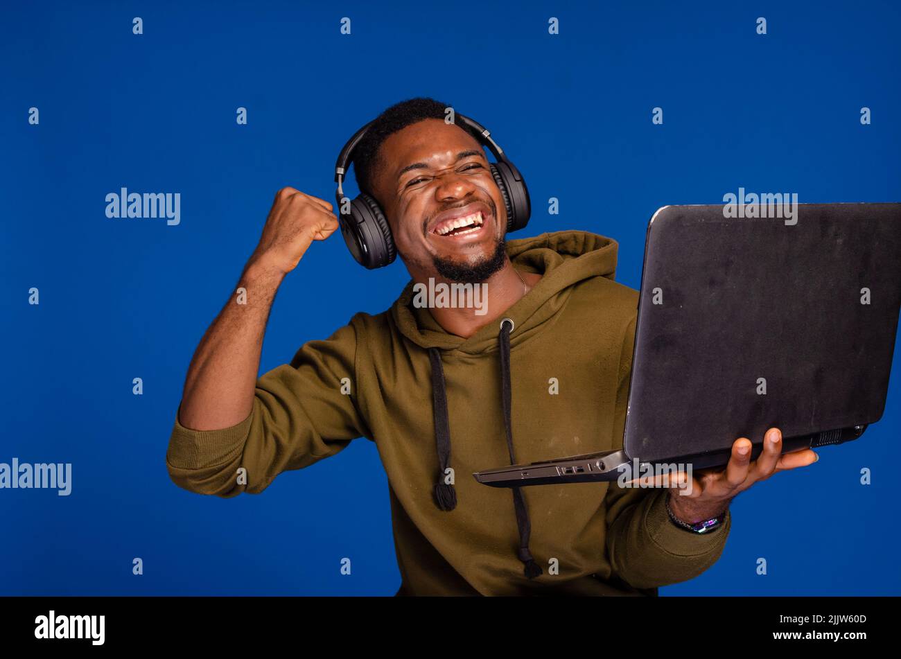 excited guy using laptop and headset Stock Photo
