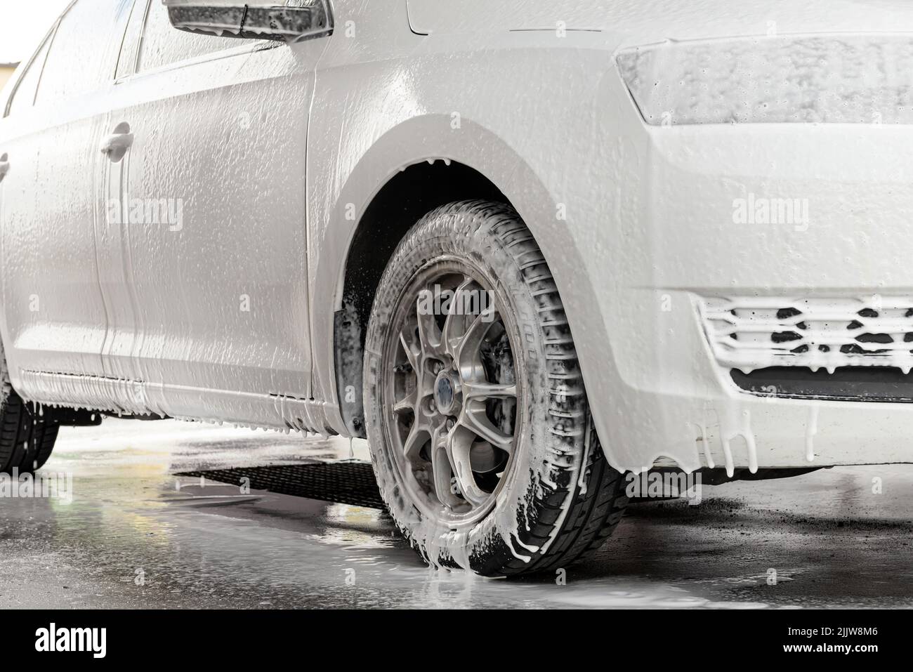 The process of washing a white car at a selfservice car wash Stock