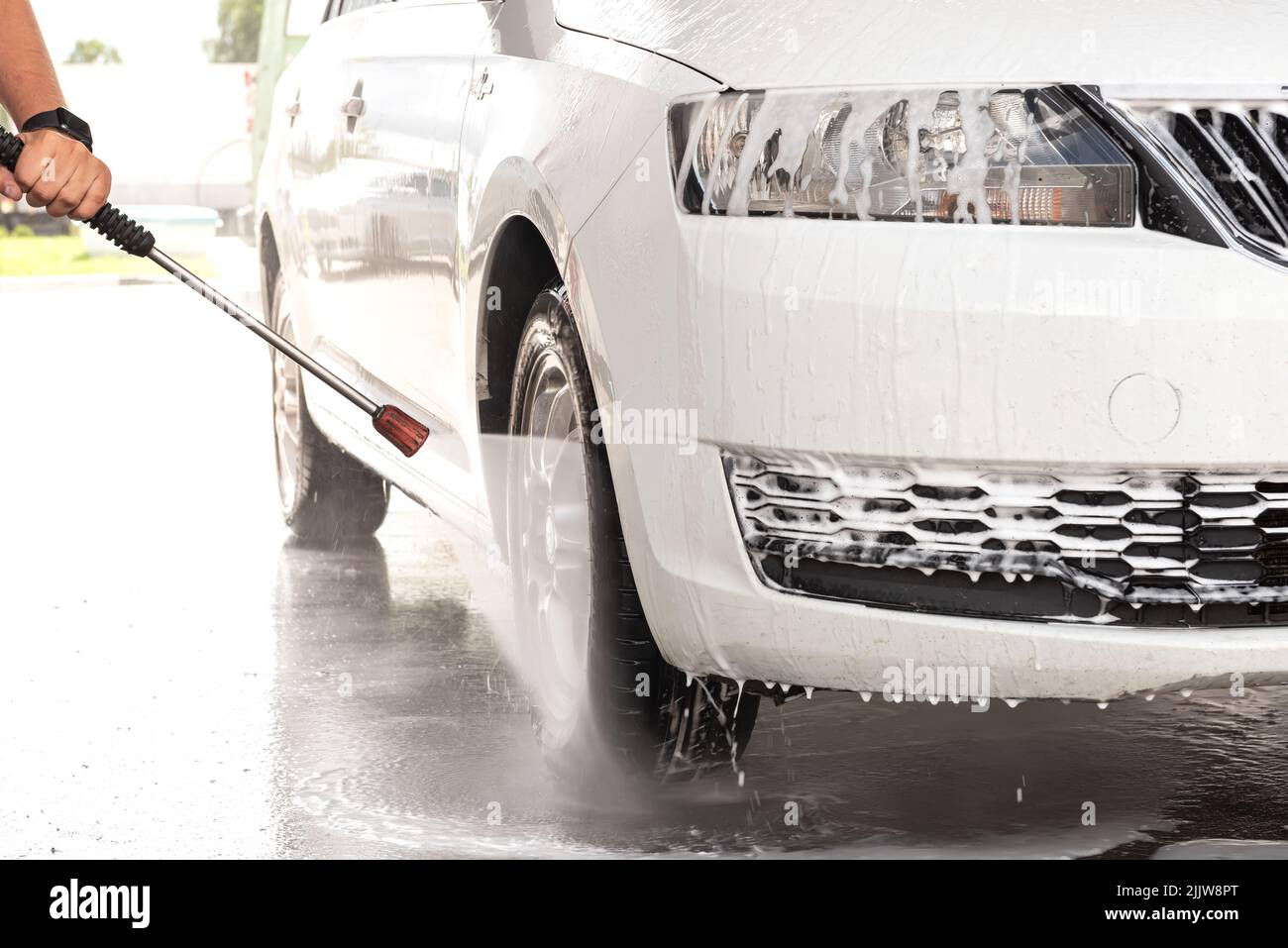 The process of washing a white car at a selfservice car wash Stock