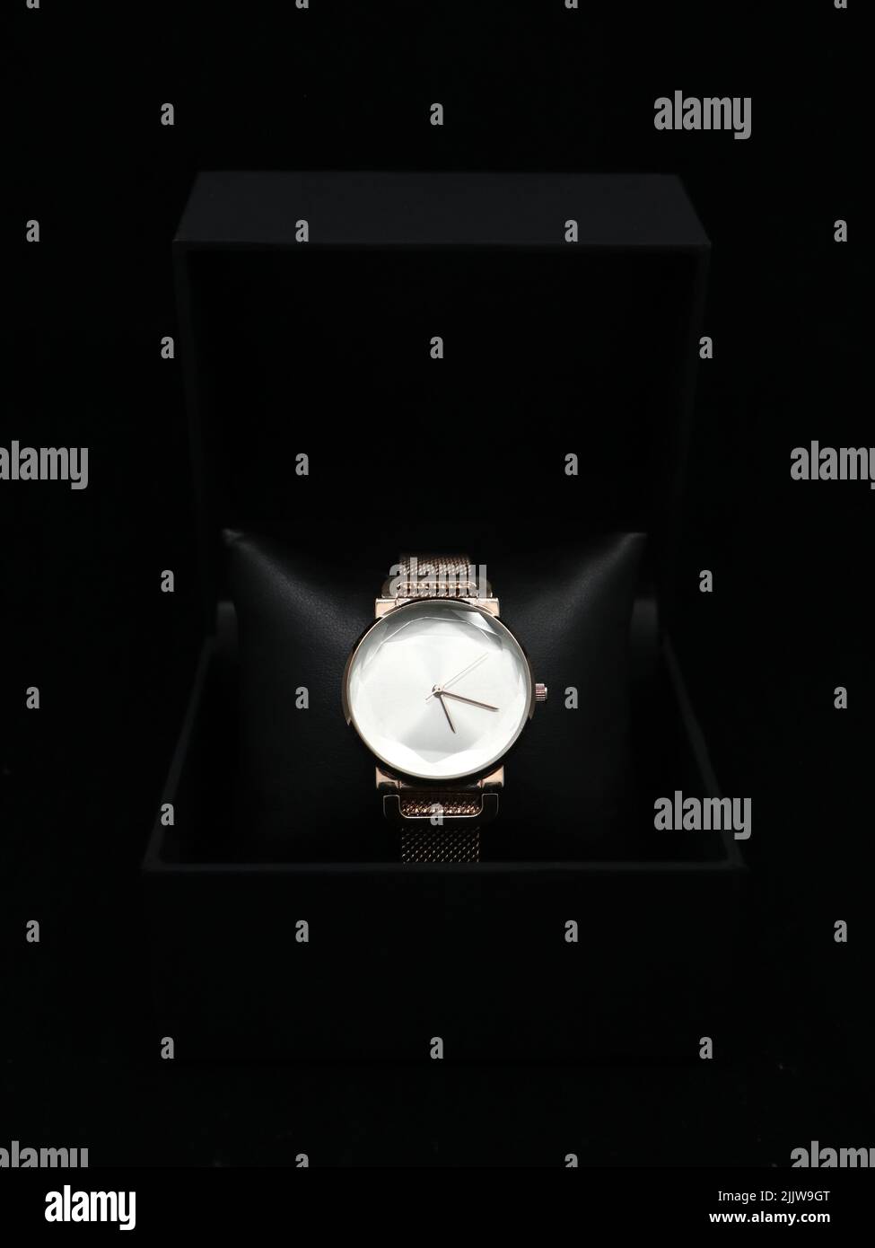 women's luxury analogue watch, rose gold in color placed inside a black box isolated in a black background Stock Photo