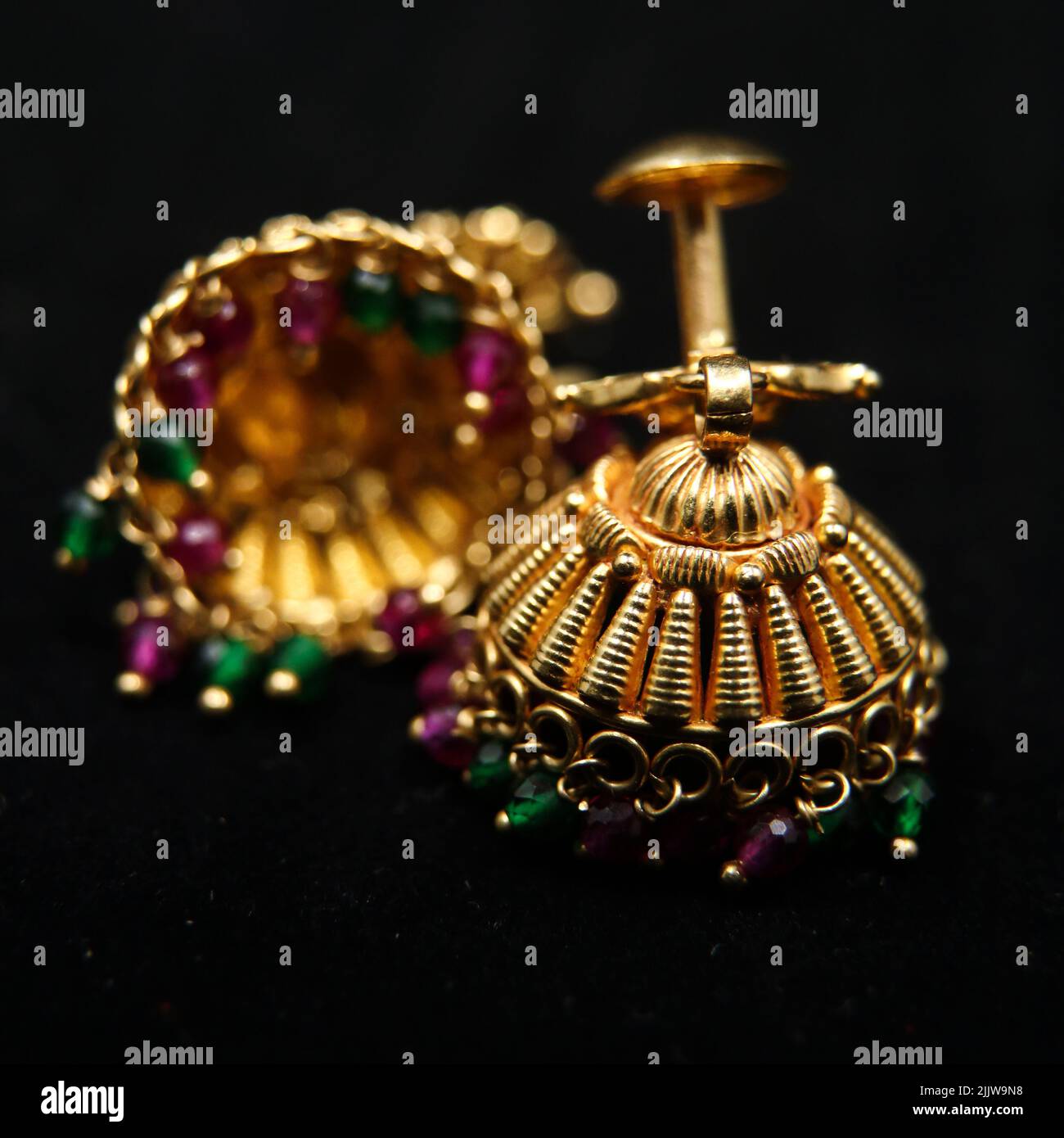 antique earrings called jhumkas made of gold with precious stones from