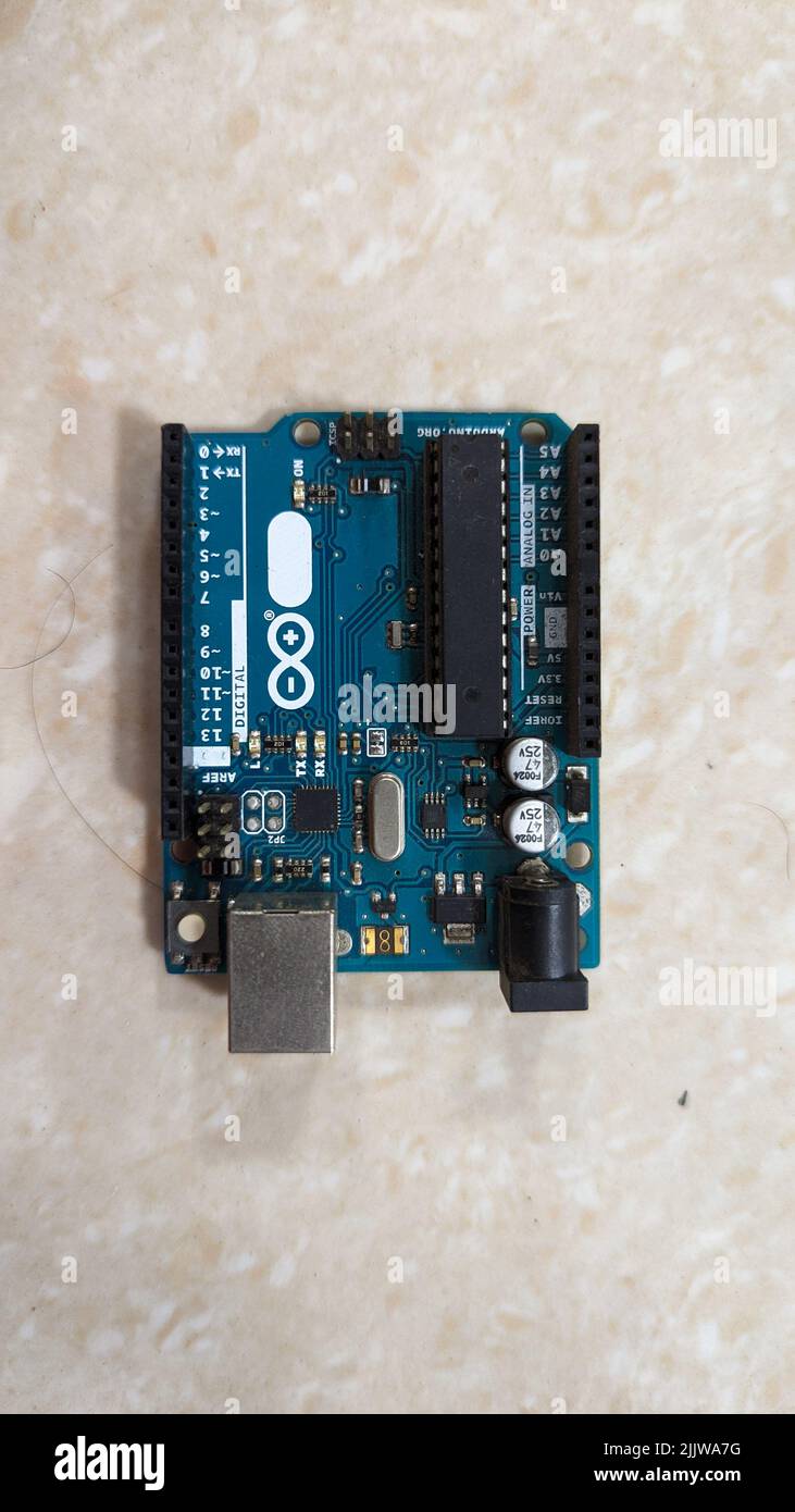 Arduino Uno microcontroller board with components and specifications isolated in a plain background Stock Photo
