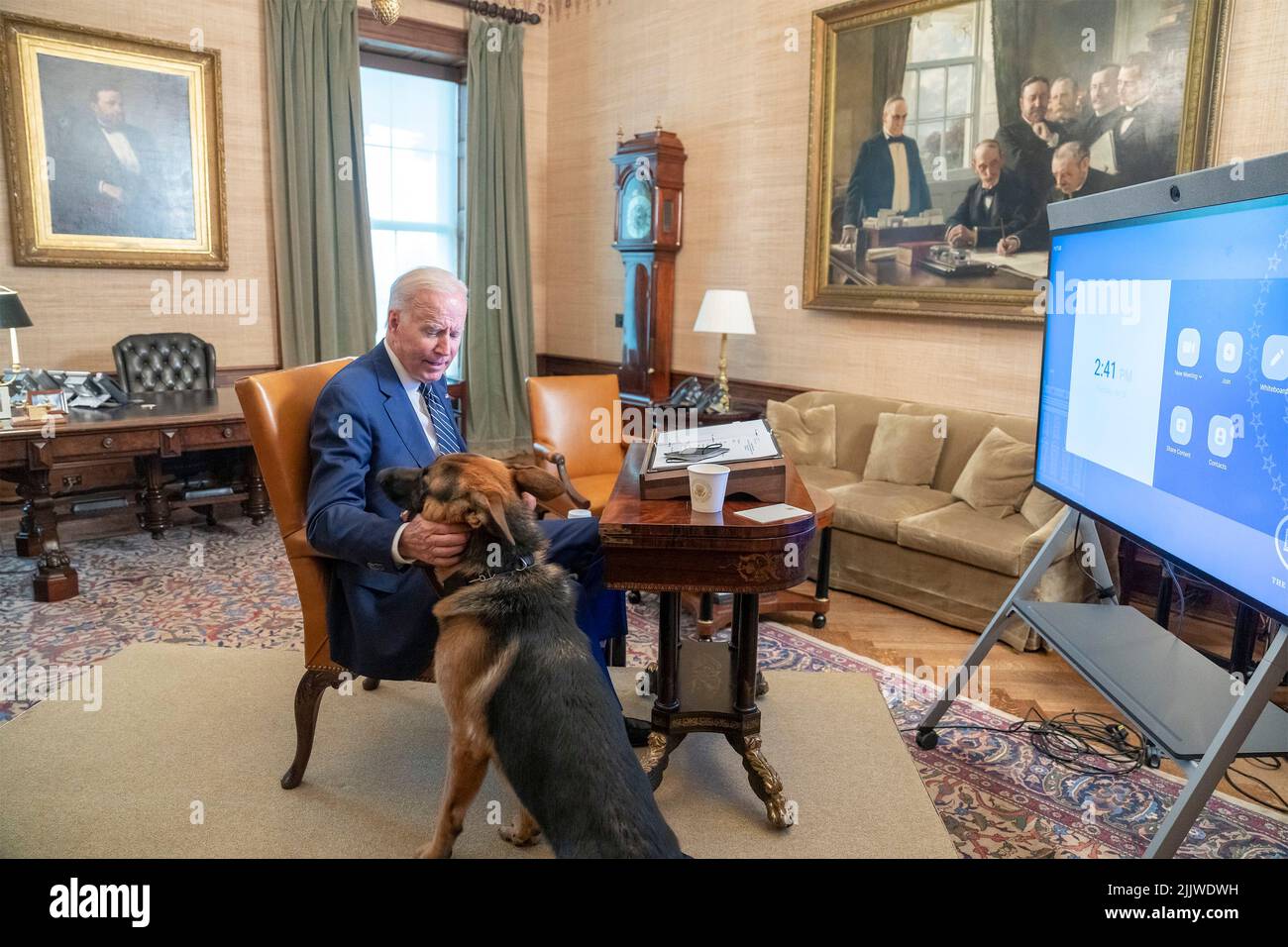 Washington, United States Of America. 26th July, 2022. Washington, United States of America. 26 July, 2022. U.S President Joe Biden, pets his German Shepard Commander after a video conference with SK Group Chairman Chey Tae-won from his private office in the residence of the White House, July 26, 2022, in Washington, DC SK Group announced $22 billion in new investments in U.S. manufacturing. Credit: Adam Schultz/White House Photo/Alamy Live News Stock Photo