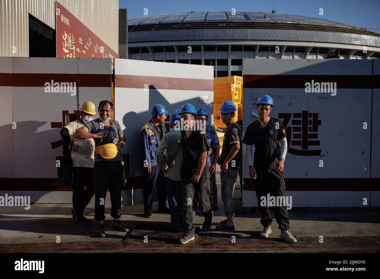 Workers leave the construction site of the new Workers' Stadium in Beijing, China, July 28, 2022. REUTERS/Thomas Peter Stock Photo