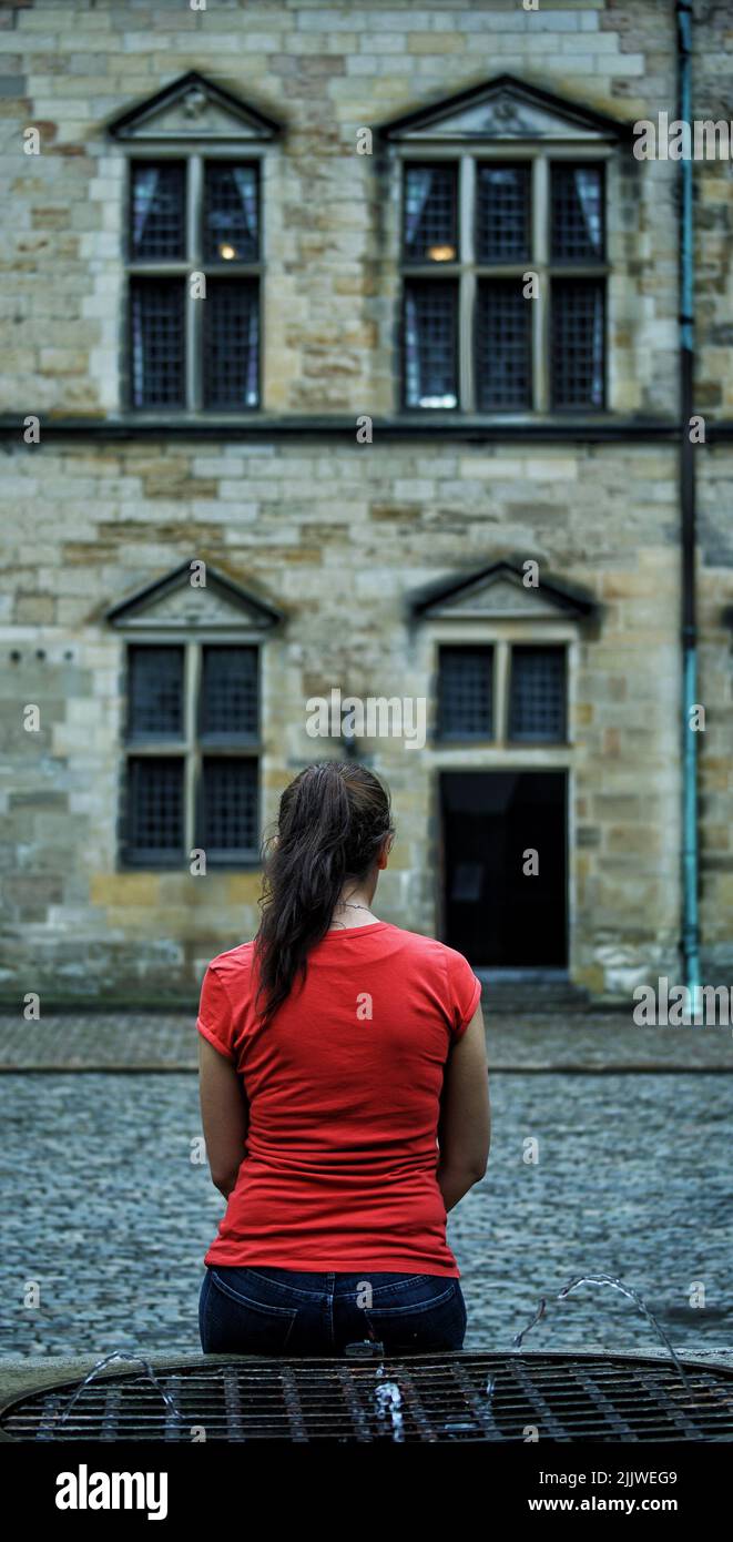 A vertical shot of a female looking at the beautiful building Stock Photo