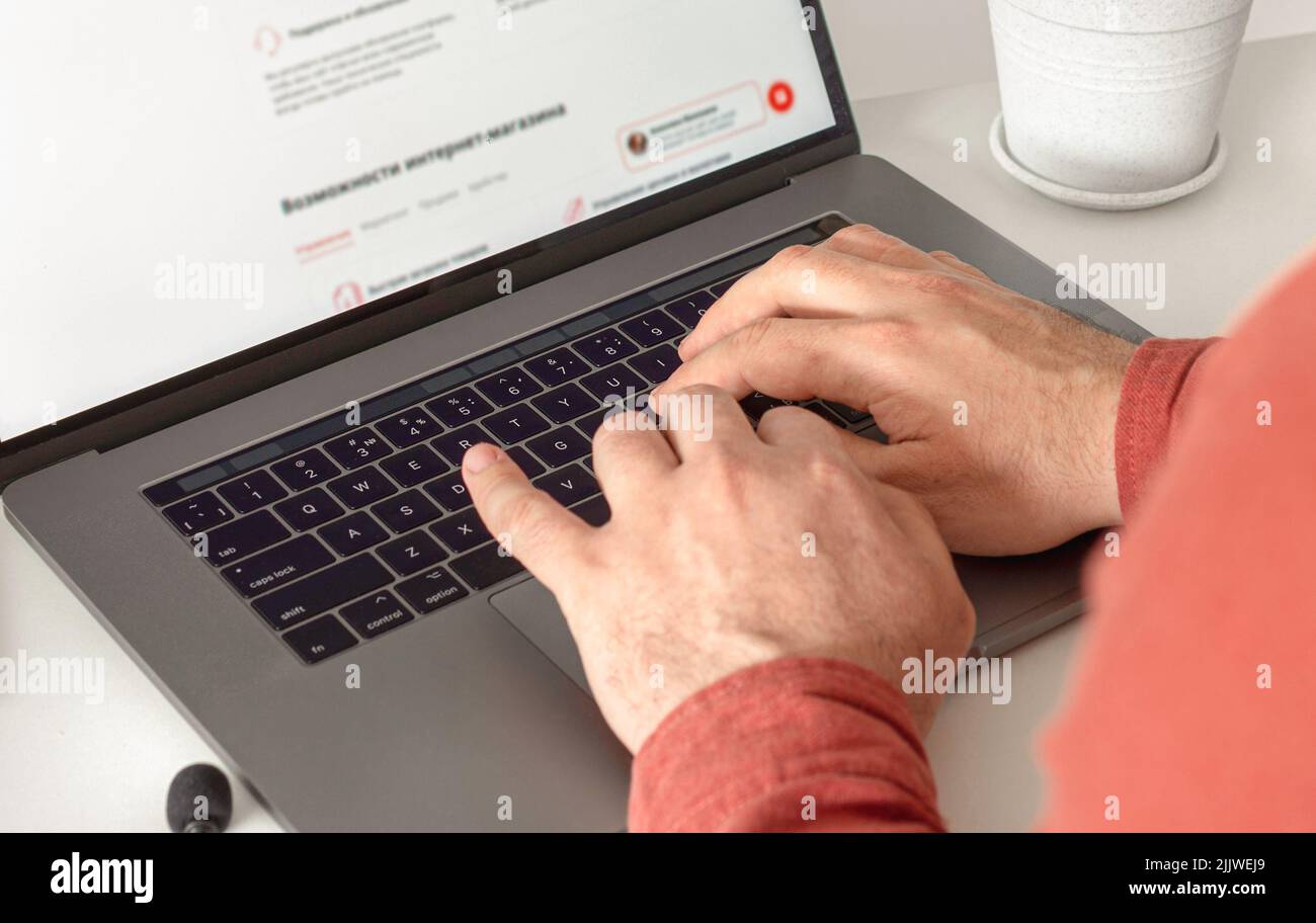 Man working on laptop in office Male hands typing text on the keyboard close up Remote work at home concept Stock Photo