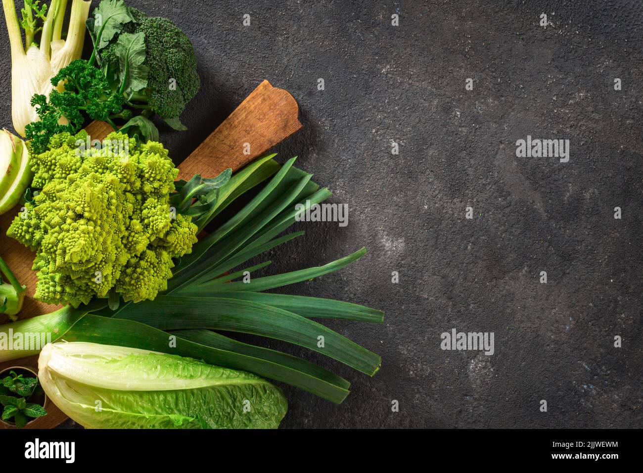 Healthy food top view Fresh green vegetables on dark background with ...