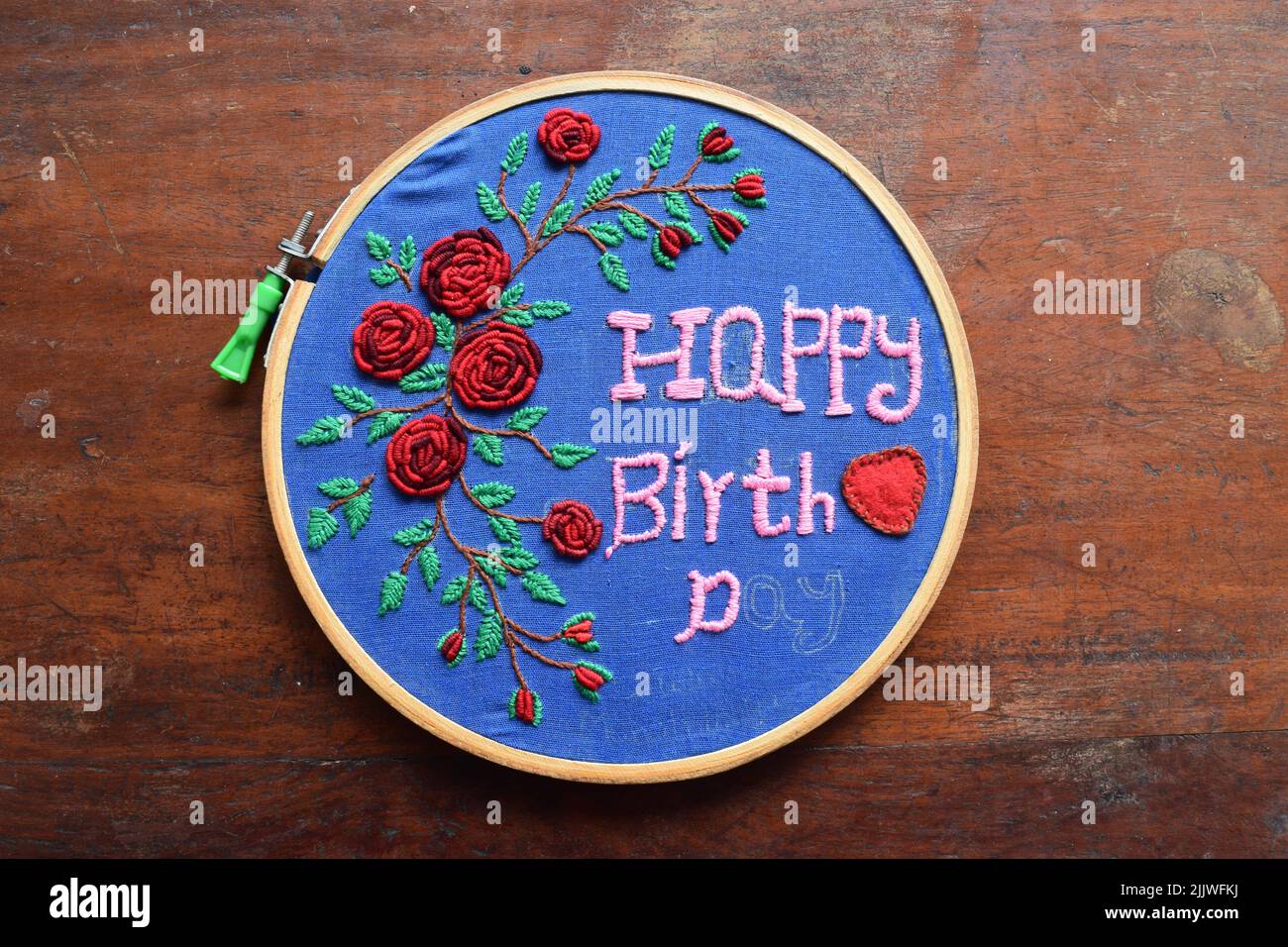 Hand embroidered happy birthday design on the fabric Stock Photo