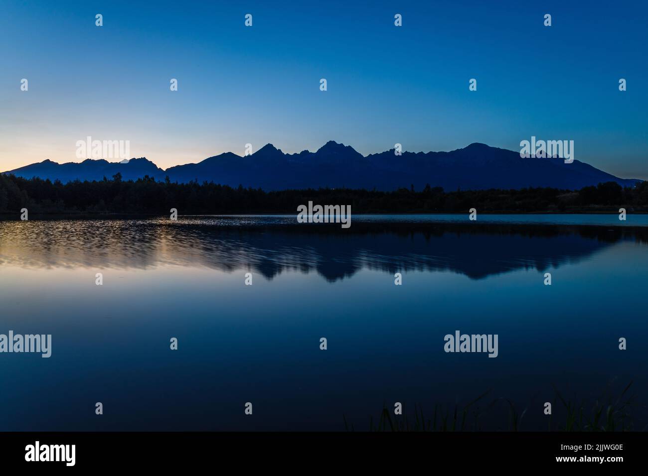 Sunset over a mountain lake and Tatras mountain in the background Stock Photo