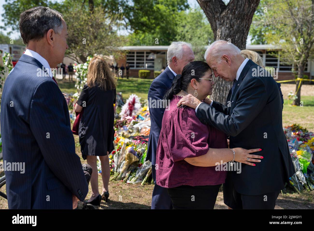Uvalde, United States of America. 29 May, 2022. U.S President Joe Biden comforts principal Mandy Gutierrez as superintendent Hal Harrell looks on as they stop to pay their respects at a makeshift memorial outside Robb Elementary School, May 29, 2022 in Uvalde, Texas. The school is the site where a gunman slaughtered 19 students and two teachers with a military style assault rifle.  Credit: Adam Schultz/White House Photo/Alamy Live News Stock Photo