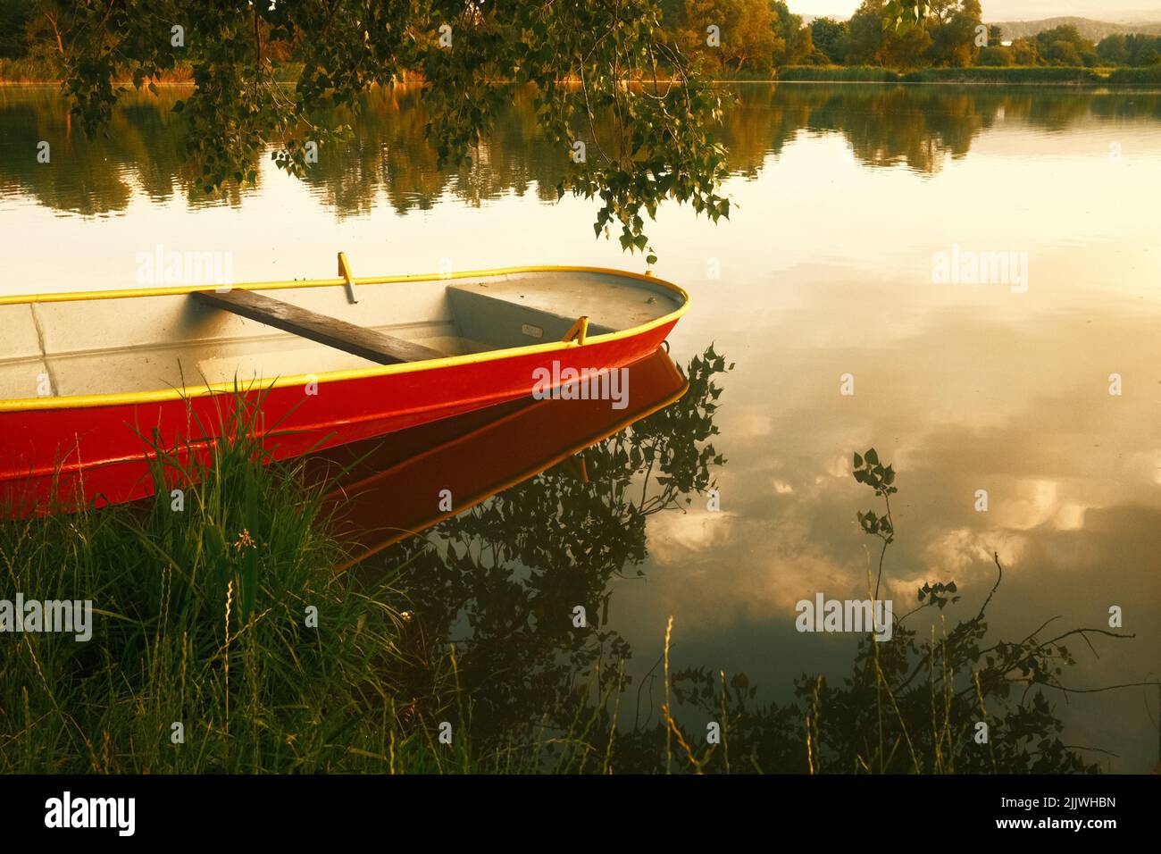 Red boat on the shore of a lake Stock Photo