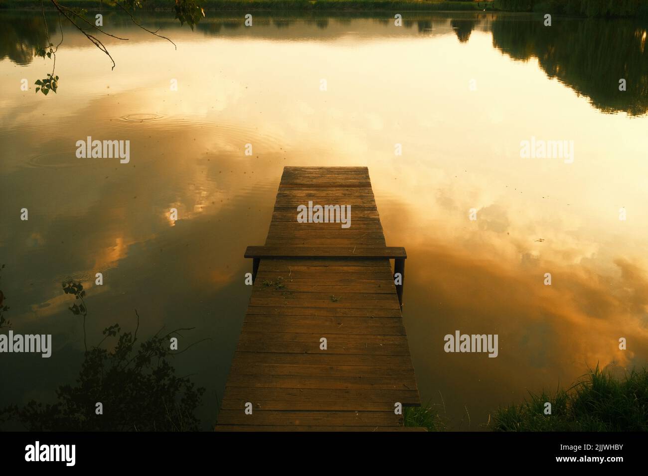 Jetty at the lake with golden evening light Stock Photo
