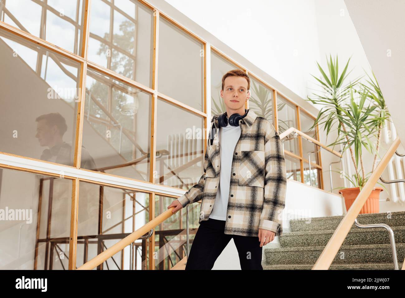 Teenager standing on stairs in high school Stock Photo