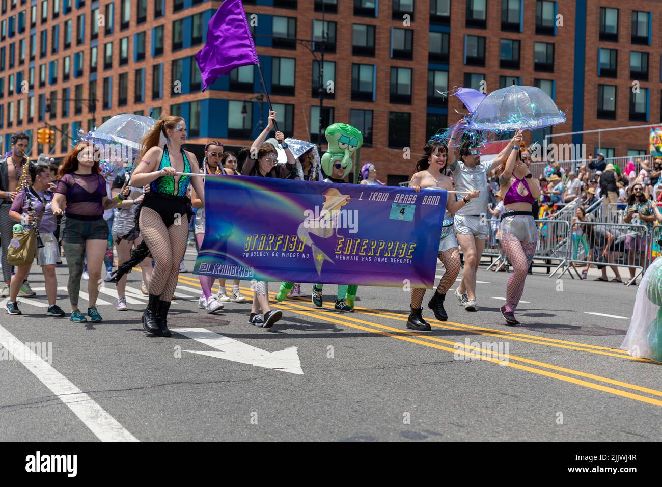 A shot of a crowd with a poster dedicated to the 40th Annual Mermaid