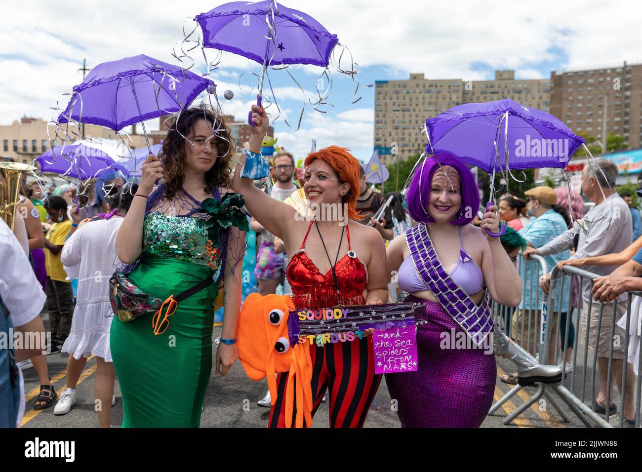 A closeup of women wearing shiny outfits with umbrellas at the 40th Annual Mermaid Parade in Coney Island Stock Photo