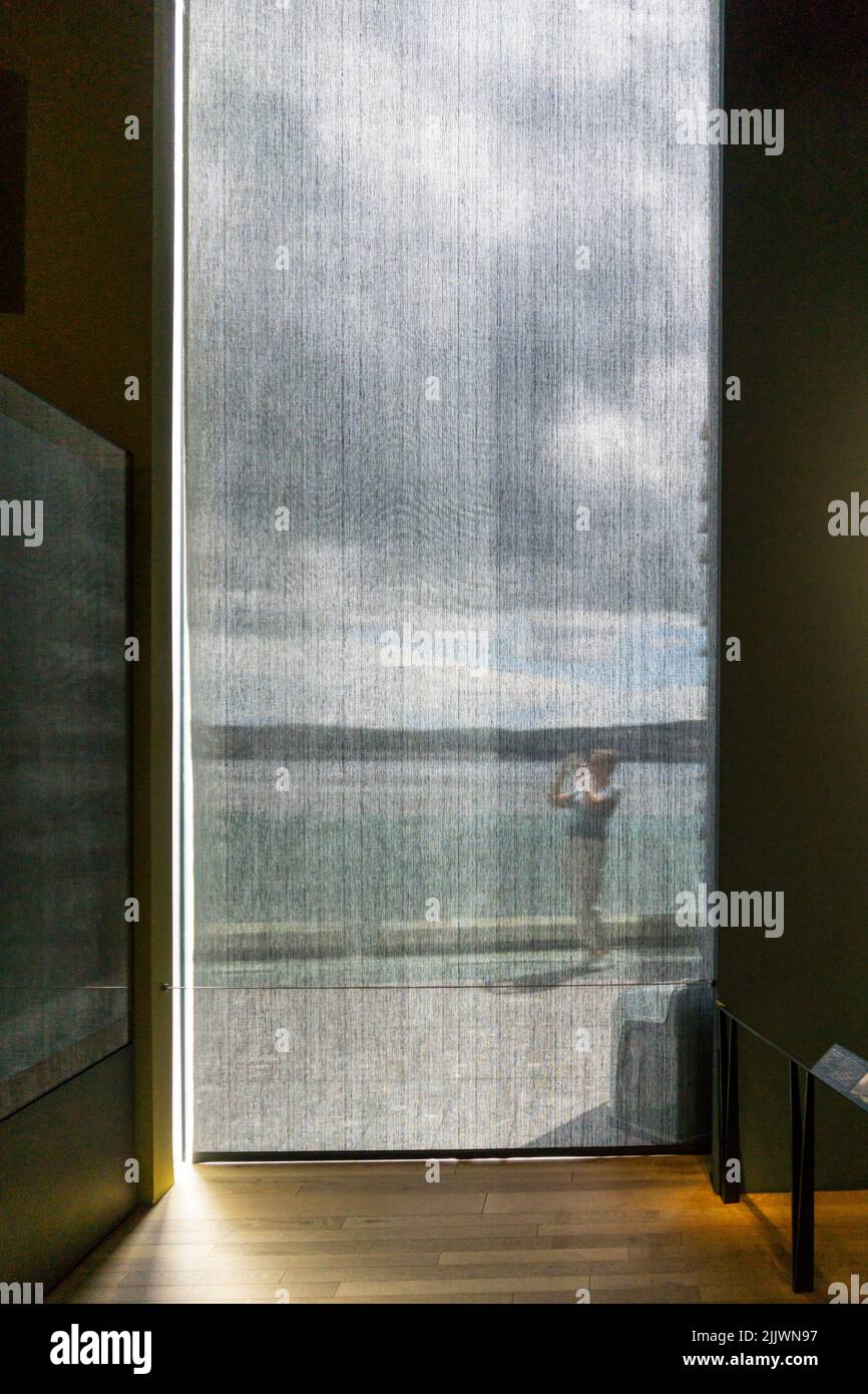 Person seen taking photograph behind a gauze screen. Stock Photo