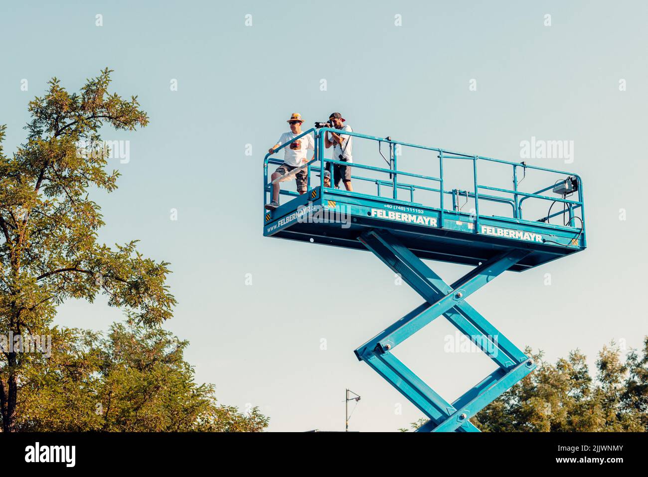 The cameramen taking pictures from blue scissor lift at the Red Bull